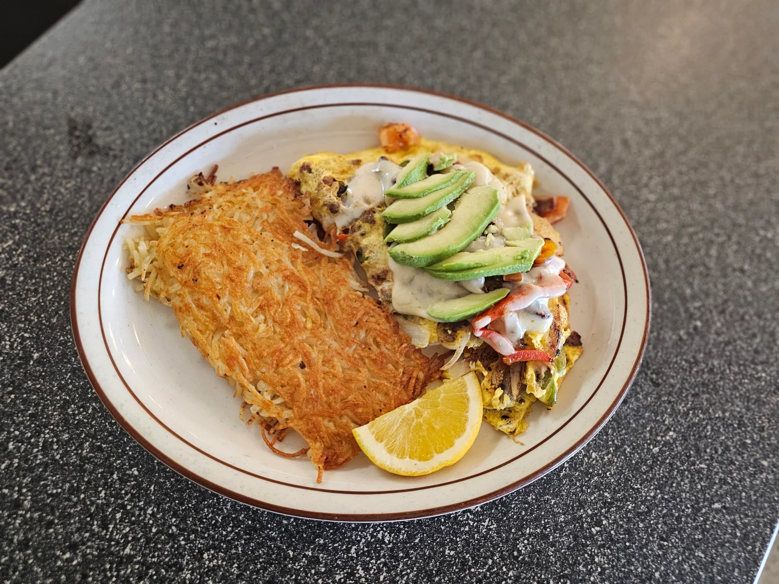 Carne asada omelet with avocado and hash browns